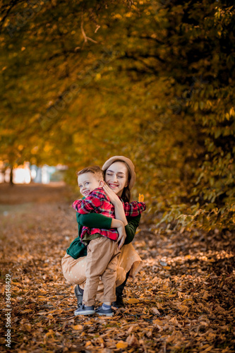Happy young mother playing and having fun with her little baby son on sunshine warm autumn day in the park. Happy family concept, Mother's Day © volody10