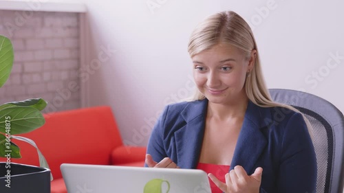 A deaf caucasian woman is making a video call and signing to relatives and friends with a laptop at home. Sign language. Technology, modern generation, family, connection, authenticity. - slow motion