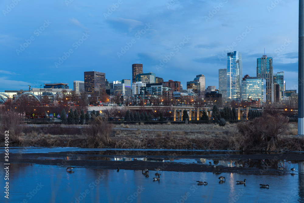 Fototapeta premium late view of a city after sunset with water and birds in the foreground