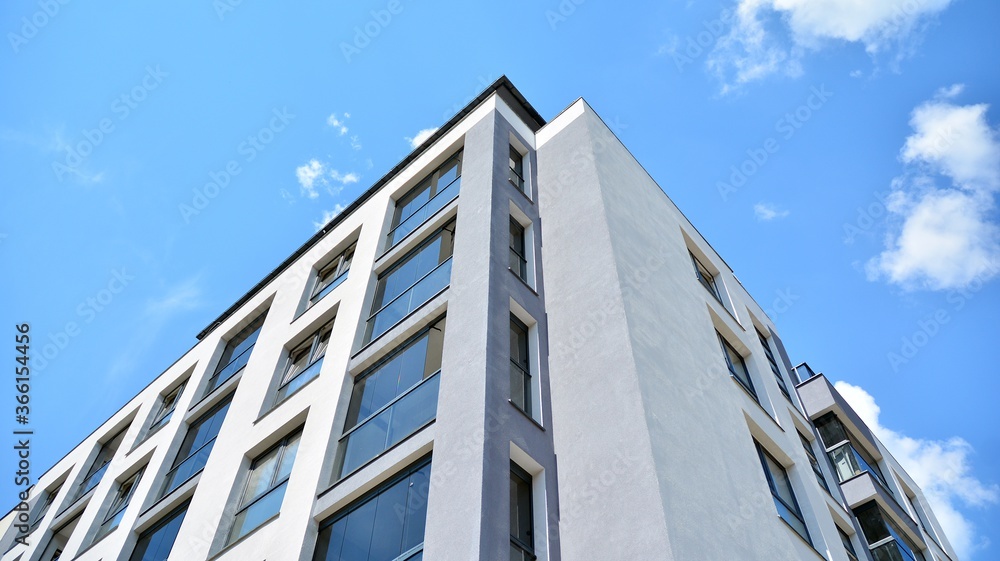 Modern apartment buildings on a sunny day with a blue sky. Facade of a modern apartment building. Glass surface with sunlight.