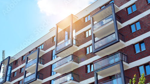 Modern apartment buildings on a sunny day with a blue sky. Facade of a modern apartment building. Glass surface with sunlight.