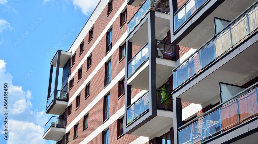 Modern apartment buildings on a sunny day with a blue sky. Facade of a modern apartment building. Glass surface with sunlight.