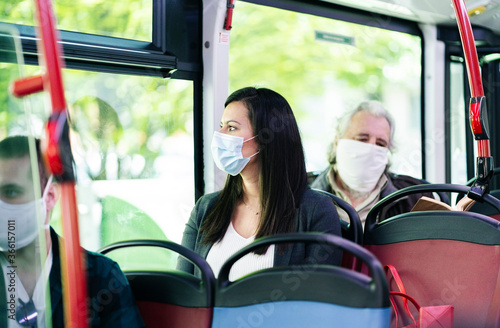 Woman wearing protective mask sitting in bus looking out of window, Spain