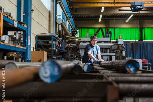 Man working with metal bars in a factory