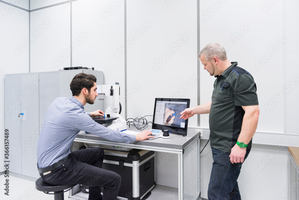 Two men working at desk in a factory Two men working at desk in a factory