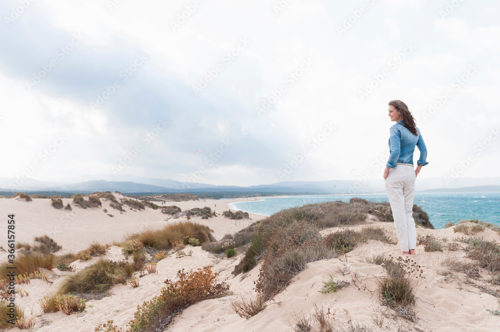 Woman standing in the dunes enjoying view, Sardinia, Italy Woman standing in the dunes enjoying view, Sardinia, Italy