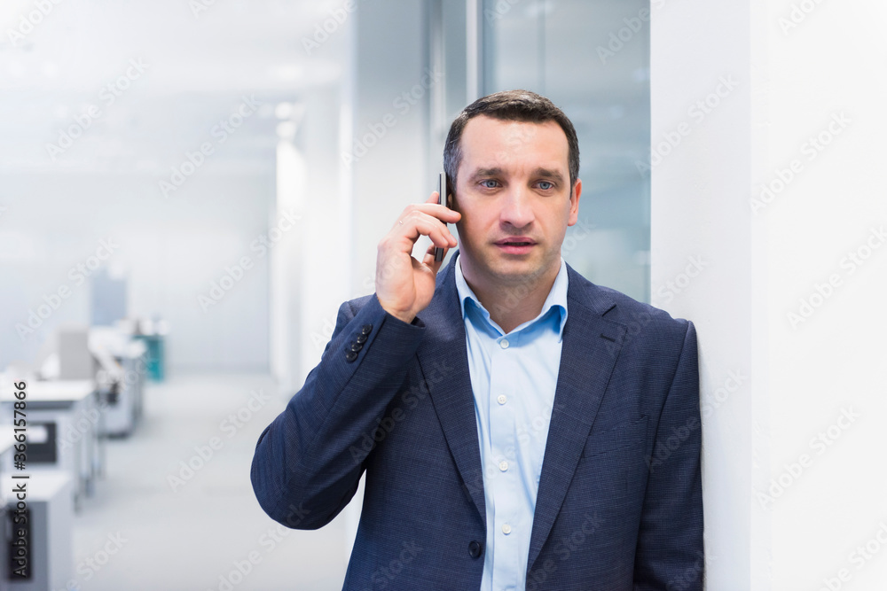 Businessman talking on the phone in office Businessman talking on the phone in office