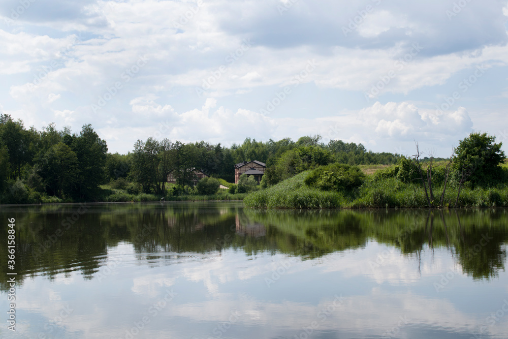 Landscape background with houses near a forest lake. 