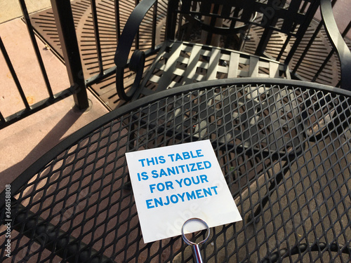 Sign on a restaurant's outdoor table informing customers that is has been sanitized.