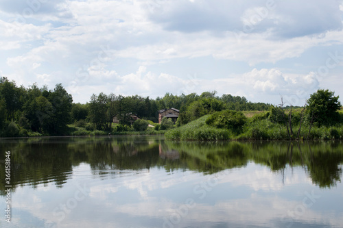 Landscape background with houses near a forest lake. 