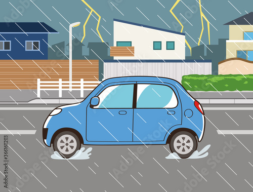 豪雨と雷の中で運転する青い自動車
