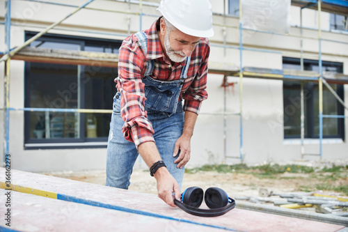 Construction worker with ear muff working at construction site photo