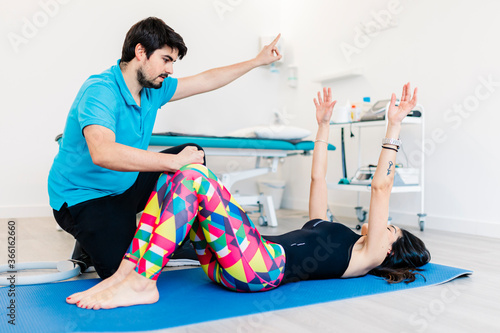 Visually impaired physical therapist instructing woman in exercises at clinic