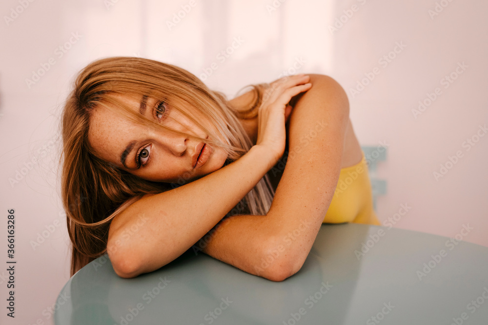 Beautiful young woman leaning on table at home Beautiful young woman leaning on table at home