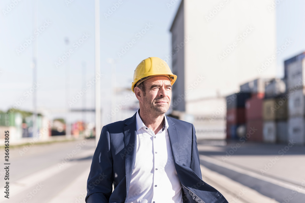 Portrait of businessman wearing safety helmet at industrial site Portrait of businessman wearing safety helmet at industrial site