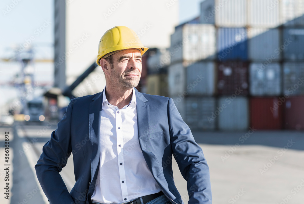 Portrait of businessman wearing safety helmet at industrial site Portrait of businessman wearing safety helmet at industrial site