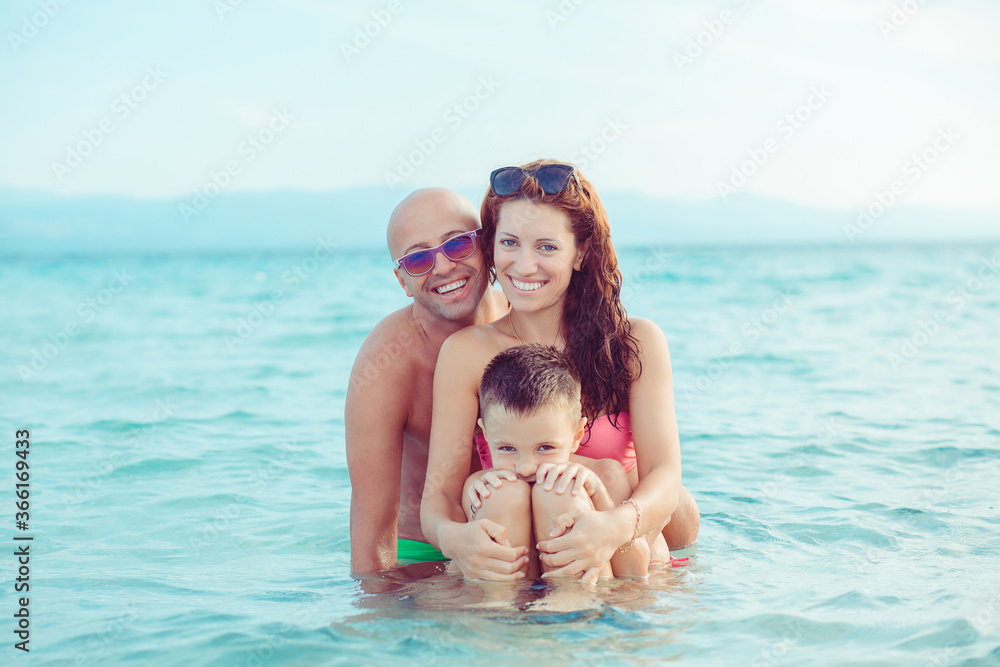 Happy family in the sea, smiling and hugging