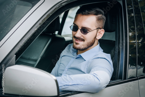 Handsome man with sunglasses sitting in his car