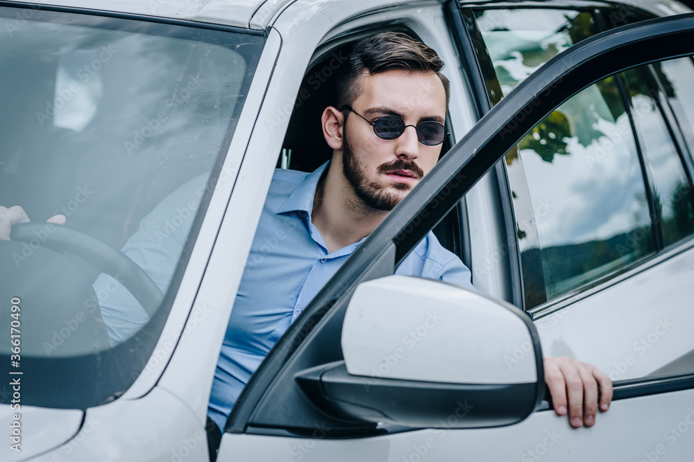 Man with sunglasses getting out of his car