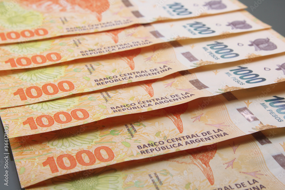 Argentine Money, Currency of Argentine, Pesos argentinos. Stack of several thousand Argentine pesos banknotes, thousand pesos cash bills on dark background. Argentine Money, Currency of Argentine, Pesos argentinos. Stack of several thousand Argentine pesos banknotes, thousand pesos cash bills on dark background.