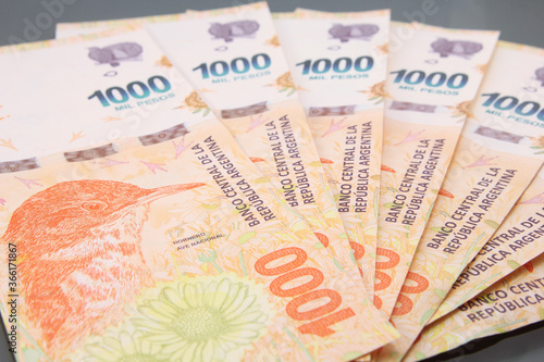 Argentine Money, Currency of Argentine, Pesos argentinos. Stack of several thousand Argentine pesos banknotes, thousand pesos cash bills on dark background.