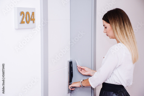 beautiful woman using her keycard to open up her hotel room 