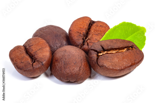 five coffee beans and a green sheet close-up on a white background, isolate
