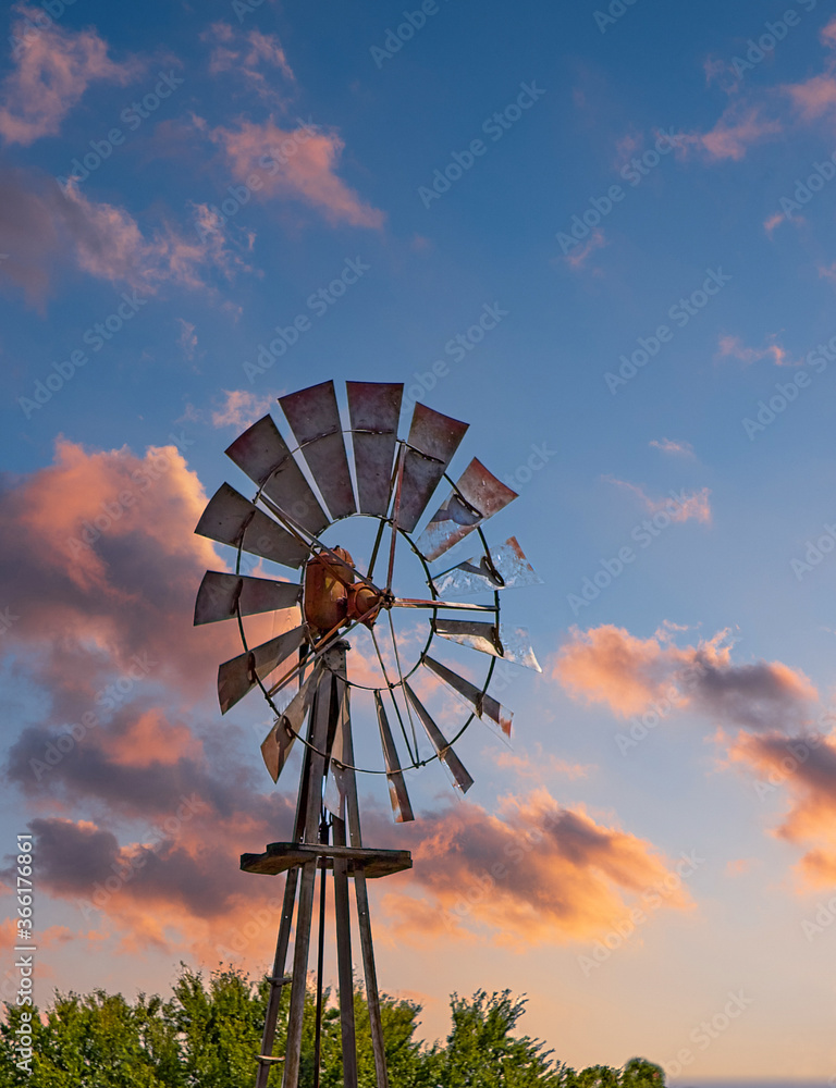 An Old Wind Mill Beyond Barns against the Sky