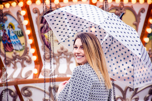 Woman enjoying her time at a amusement park holding an umbrella