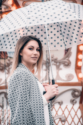 Young woman holding a dotted umbrella