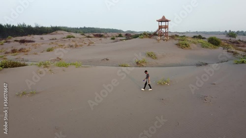 Aerial view footage of a man walking in the desert alone photo