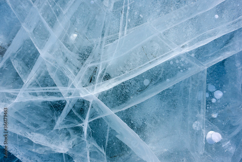 Beautiful ice of Lake Baikal with abstract cracks and frozen air bubbles