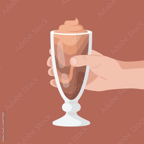 Hand holds a chocolate milkshake.
