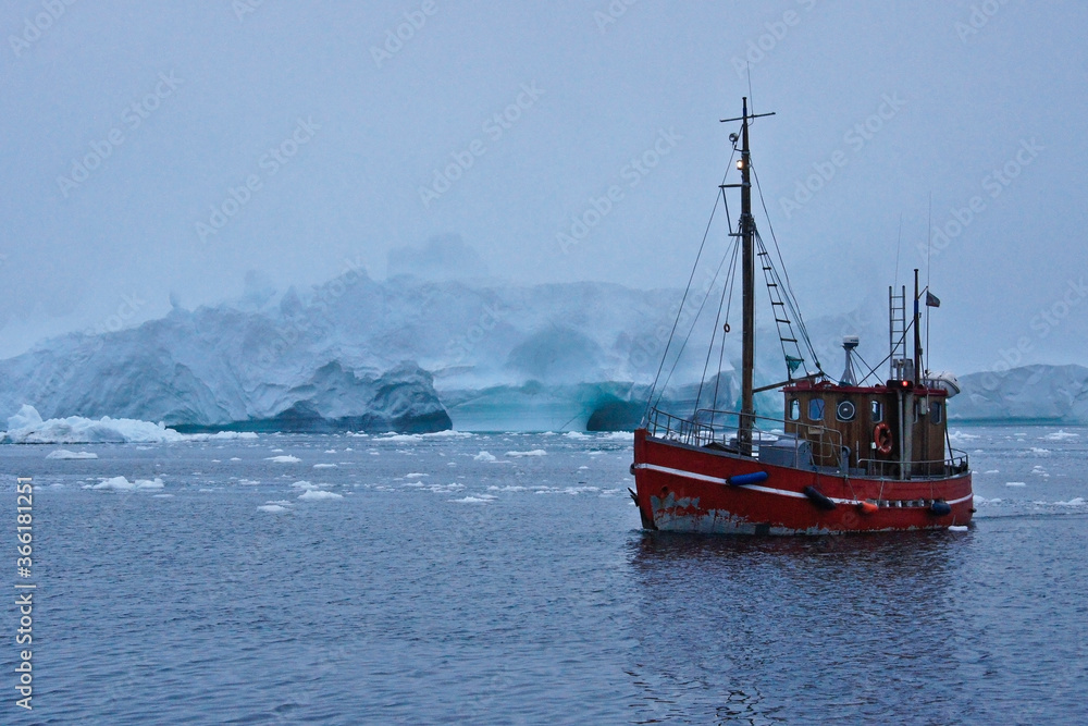 Fishing boat among icebergs in foggy Disko Bay, Ilulissat, Greenland Fishing boat among icebergs in foggy Disko Bay, Ilulissat, Greenland