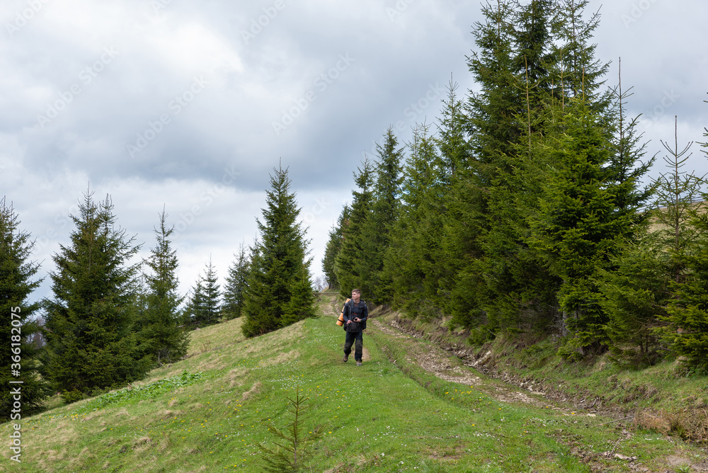 tourist man walks in the forest with a camera in his hands tourist man walks in the forest with a camera in his hands