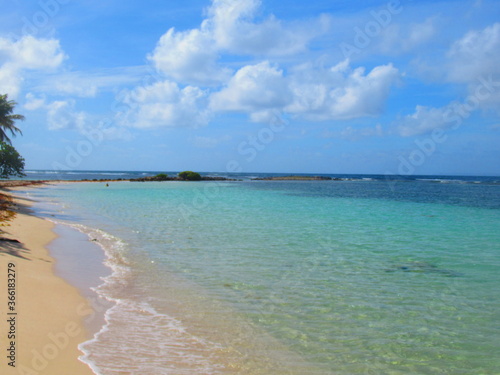 Fototapeta Naklejka Na Ścianę i Meble -  A côté de la plage de sable blanc la paradisiaque mer turquoise sous le ciel bleu 