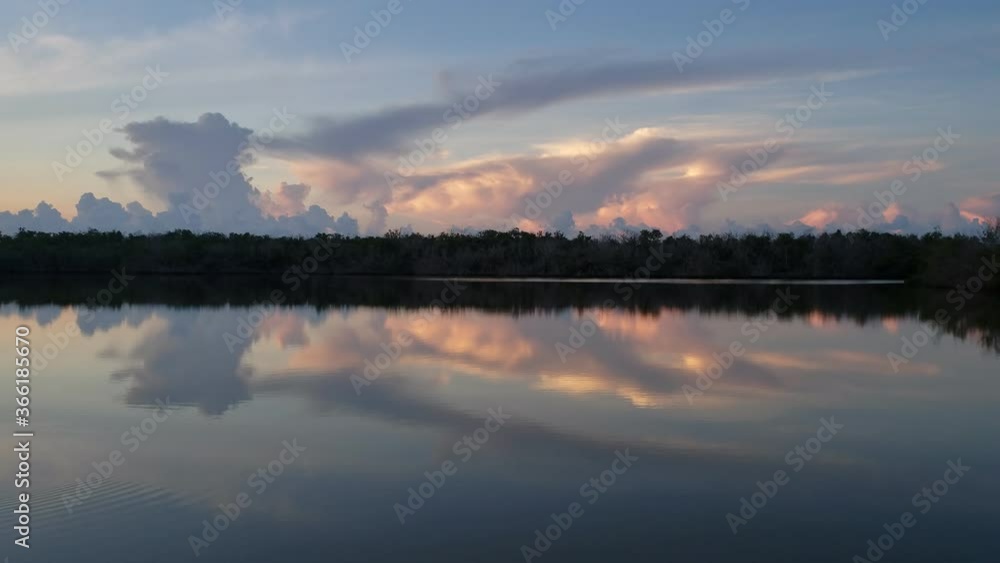 Sounds and sights of sunrise on West Lake in Everglades National Park, Florida on tranquil summer morning with colorful cloudscape reflected in calm water 4K. Sounds and sights of sunrise on West Lake in Everglades National Park, Florida on tranquil summer morning with colorful cloudscape reflected in calm water 4K.
