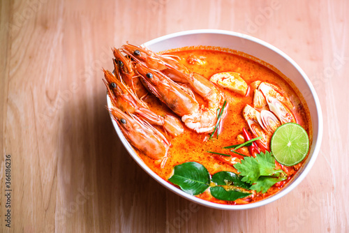  Thai hot spicy soup shrimp in coconut milk or Tom Yum Goong on wooden table photo