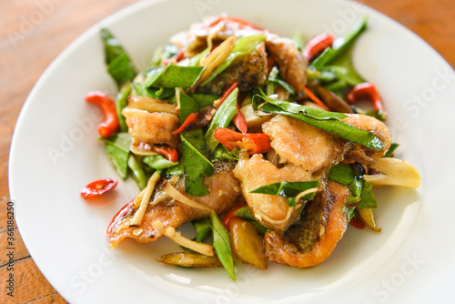 Thai food stir fried fish with pepper chili and herb on white plate - Tilapia fish cooked food