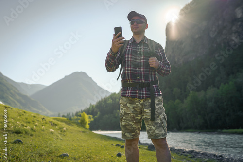 man with phone in the mountains