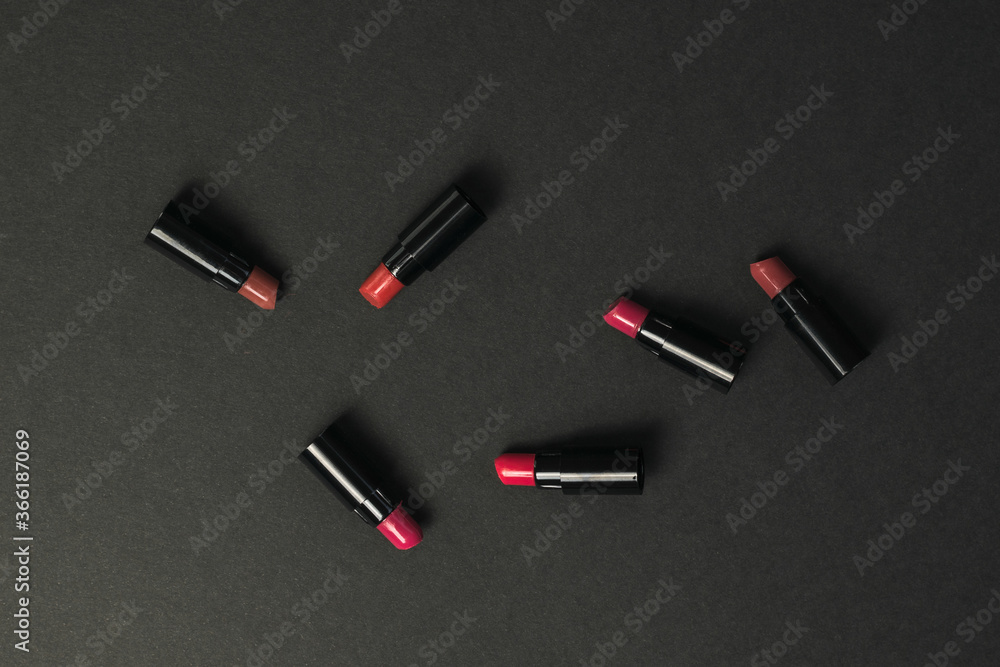 Lipstick samples scattered on the black table. Lipstick samples scattered on the black table.