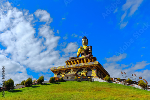 The statue of Buddha at the Buddha park with blue sky and clouds in the background as seen from Rabongla in Sikkim India photo