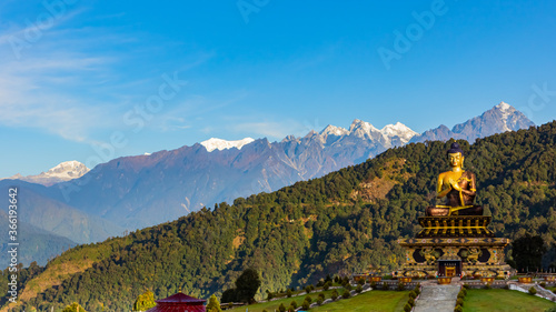 The statue of Buddha at the Buddha park with snow clad himalayan mountain range in the background as seen from Rabongla in Sikkim India
