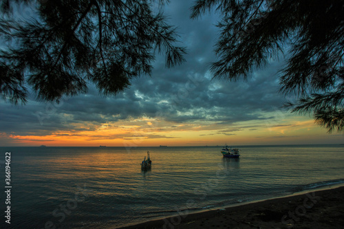Low orange sunset in dramatic clouds over ocean in Pathek Beach Sirubondo, Indonesia. © Mohammad
