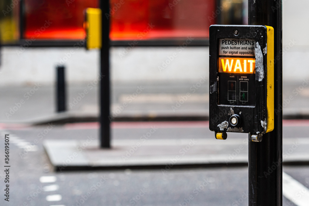 Crosswalk button for pedestrian with light warning on a defocused background , London, UK Crosswalk button for pedestrian with light warning on a defocused background , London, UK