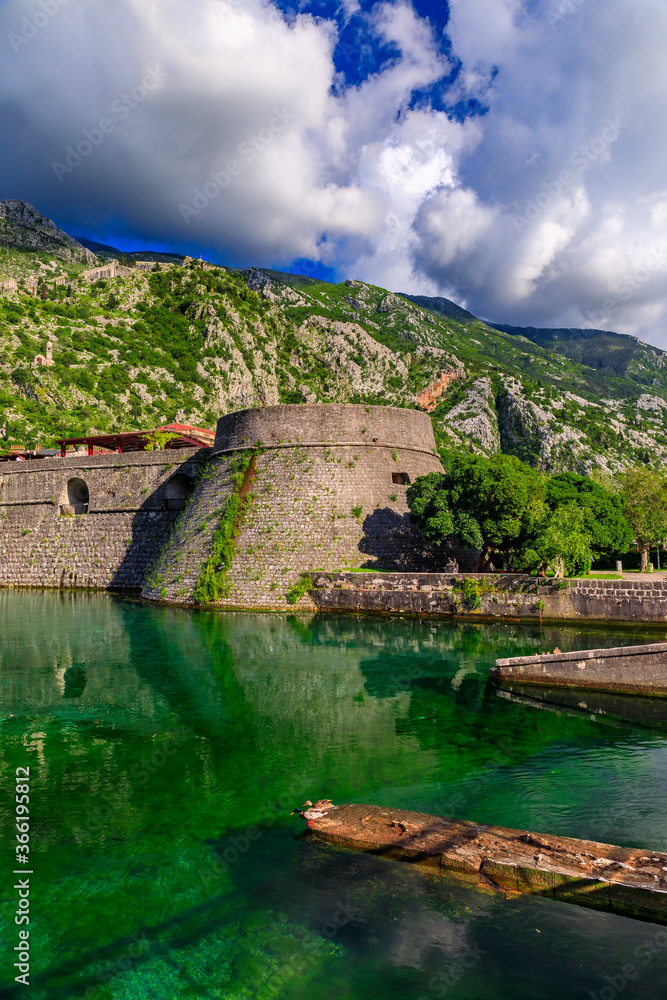 Emerald green waters of Kotor Bay or Boka Kotorska and the ancient wall of Kotor former Venetian fortress in Montenegro