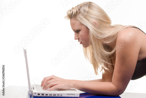 Young blonde woman checking her computer