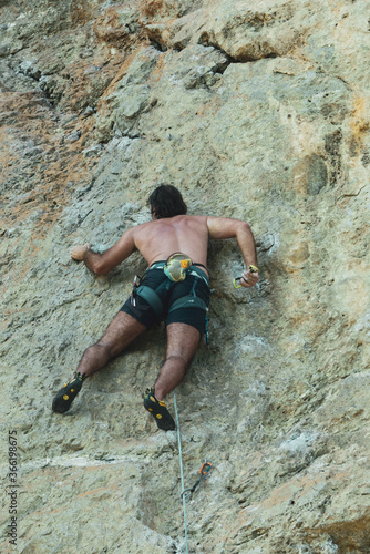 free climber in azione su una parete rocciosa a picco sul mare