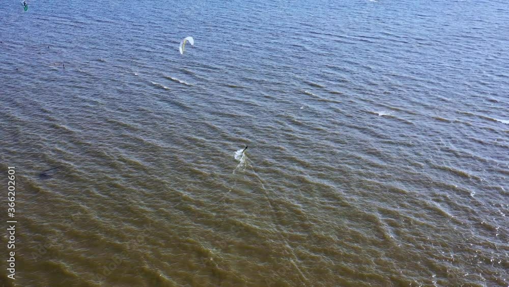 Aerial view young people kite surfing ride on the waves in the Baltic Sea, Drone view of the ocean and people engaged in extreme sports, kitesurfing. Summer Fun Action Sport Aerial view young people kite surfing ride on the waves in the Baltic Sea, Drone view of the ocean and people engaged in extreme sports, kitesurfing. Summer Fun Action Sport