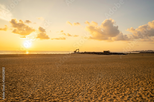 construction work on the beach during sunrise with a cloudy sky
